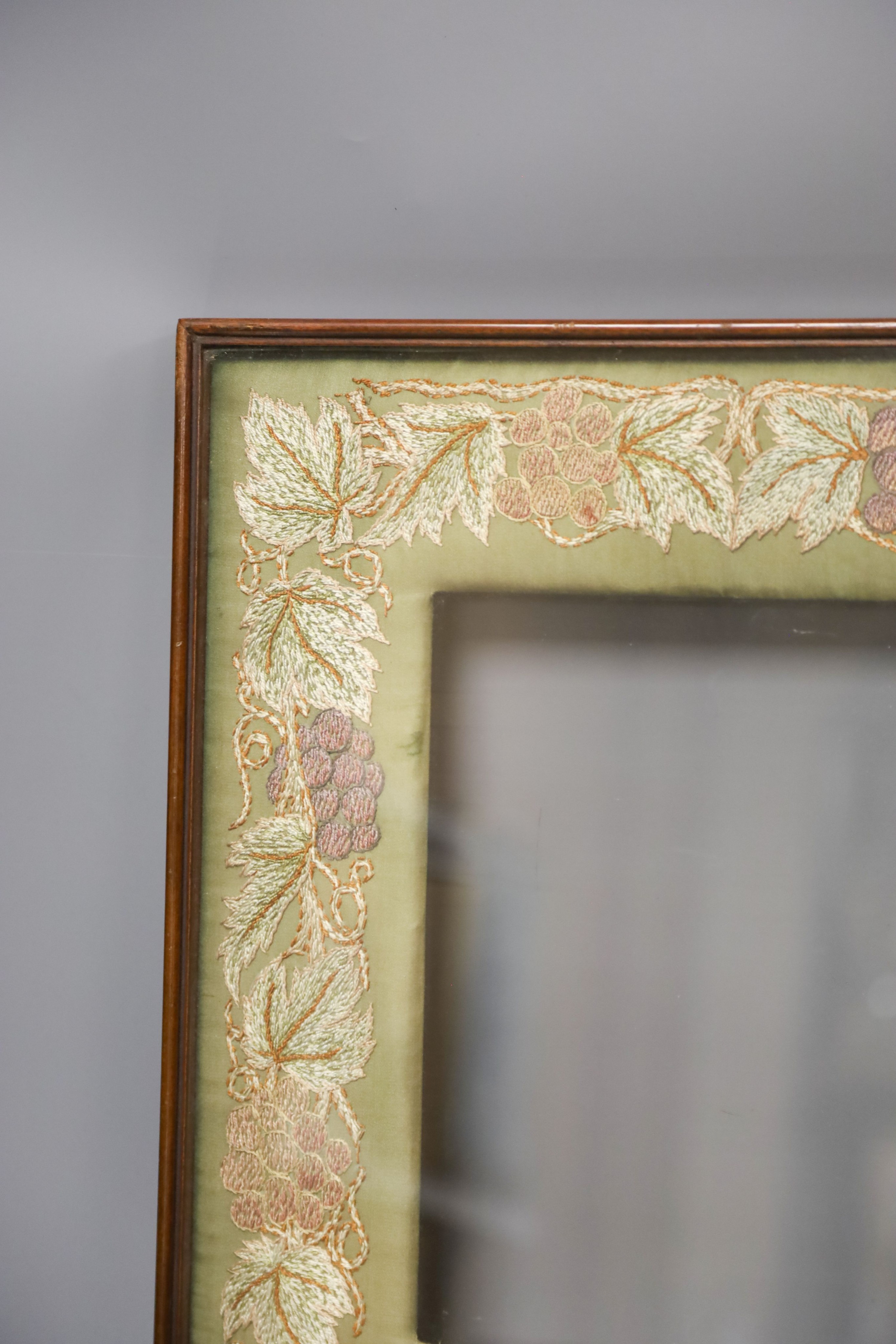 A mahogany picture frame with needlework mount 48x42cm